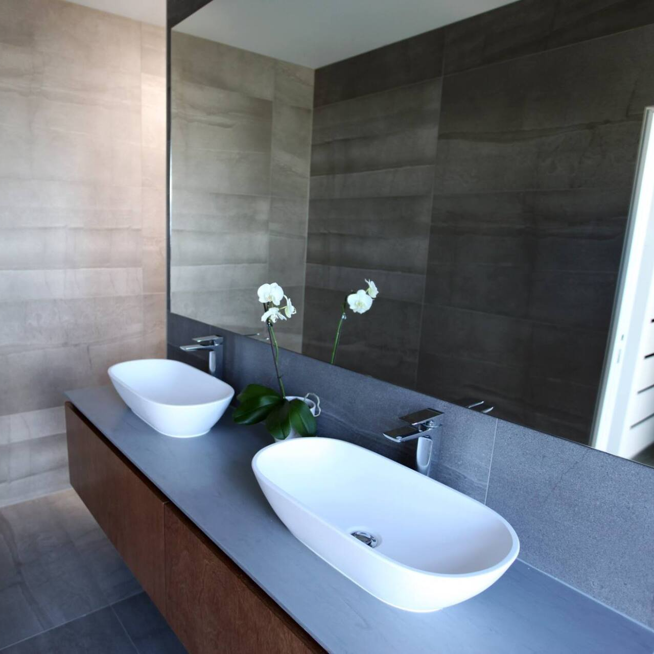 A bathroom with two sinks and a large mirror
