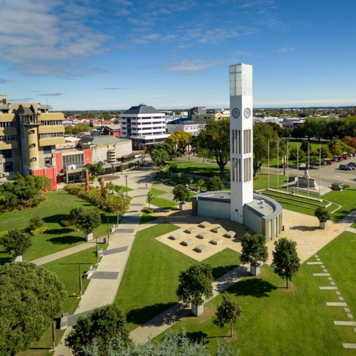 An aerial view of a park with a clock tower in the middle