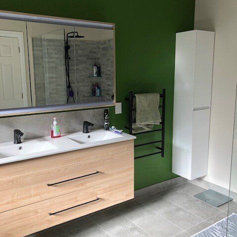 A bathroom with two sinks and a large mirror.