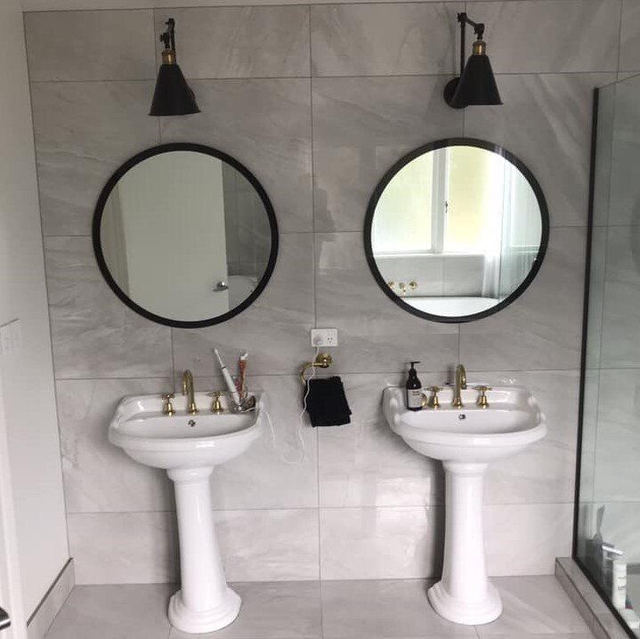 A bathroom with two sinks and two mirrors