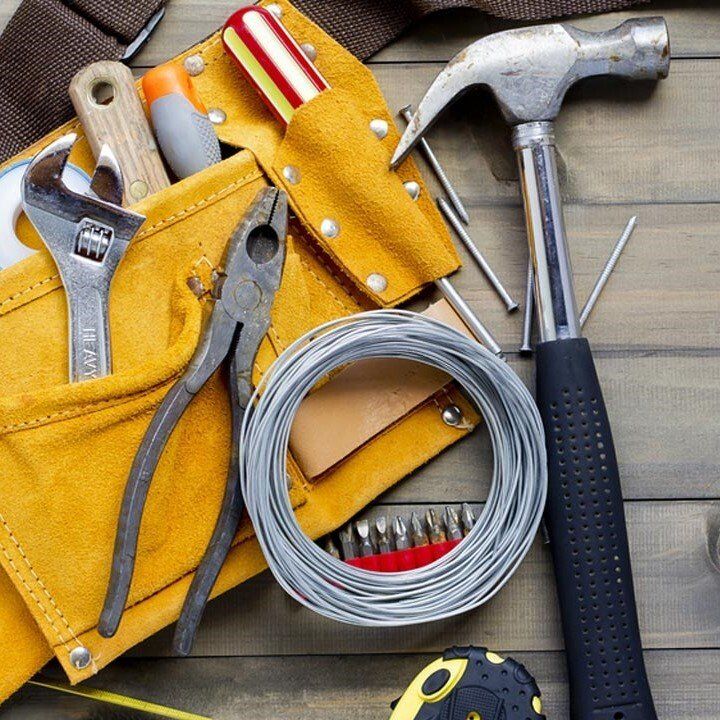 A tool belt filled with tools including a hammer and pliers