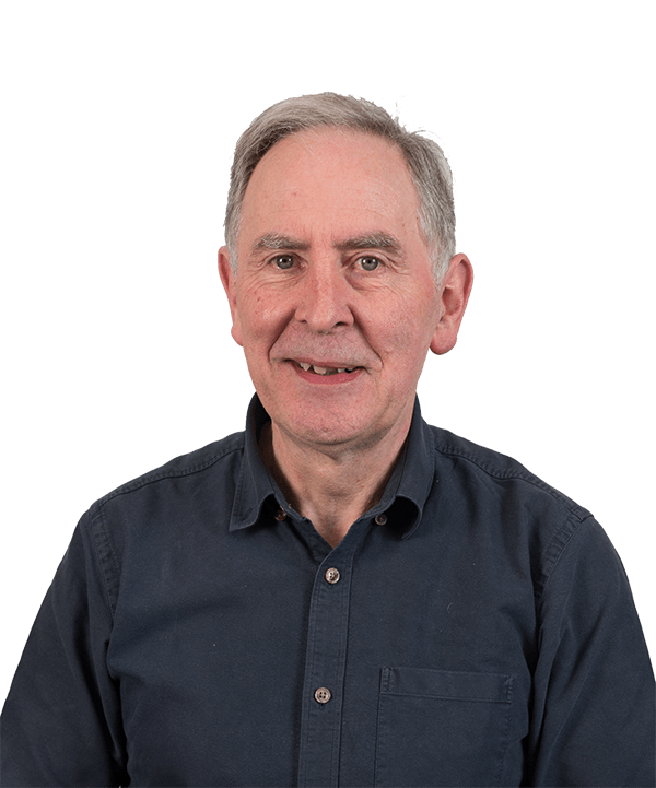 A man in a blue shirt is smiling for the camera.