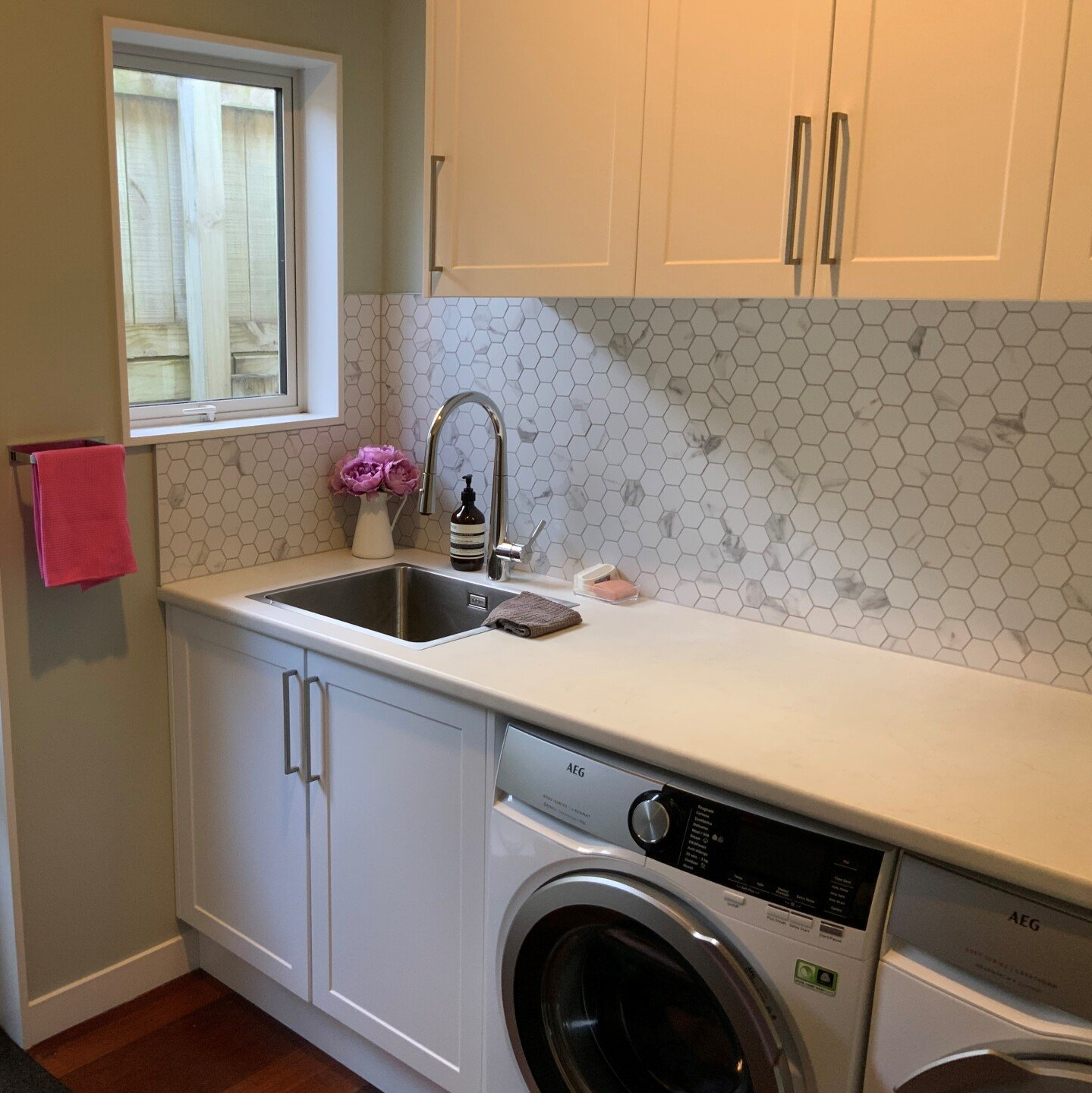 A laundry room with a washer and dryer and a sink