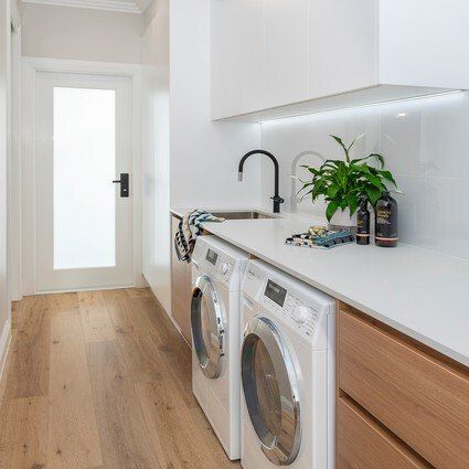 A laundry room with a washer and dryer and a sink.
