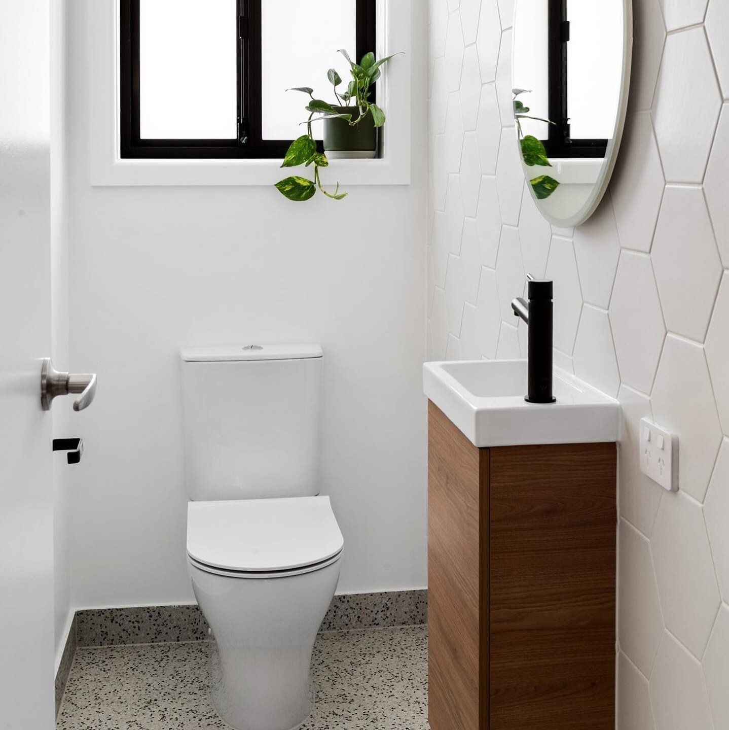 A bathroom with a toilet , sink and mirror