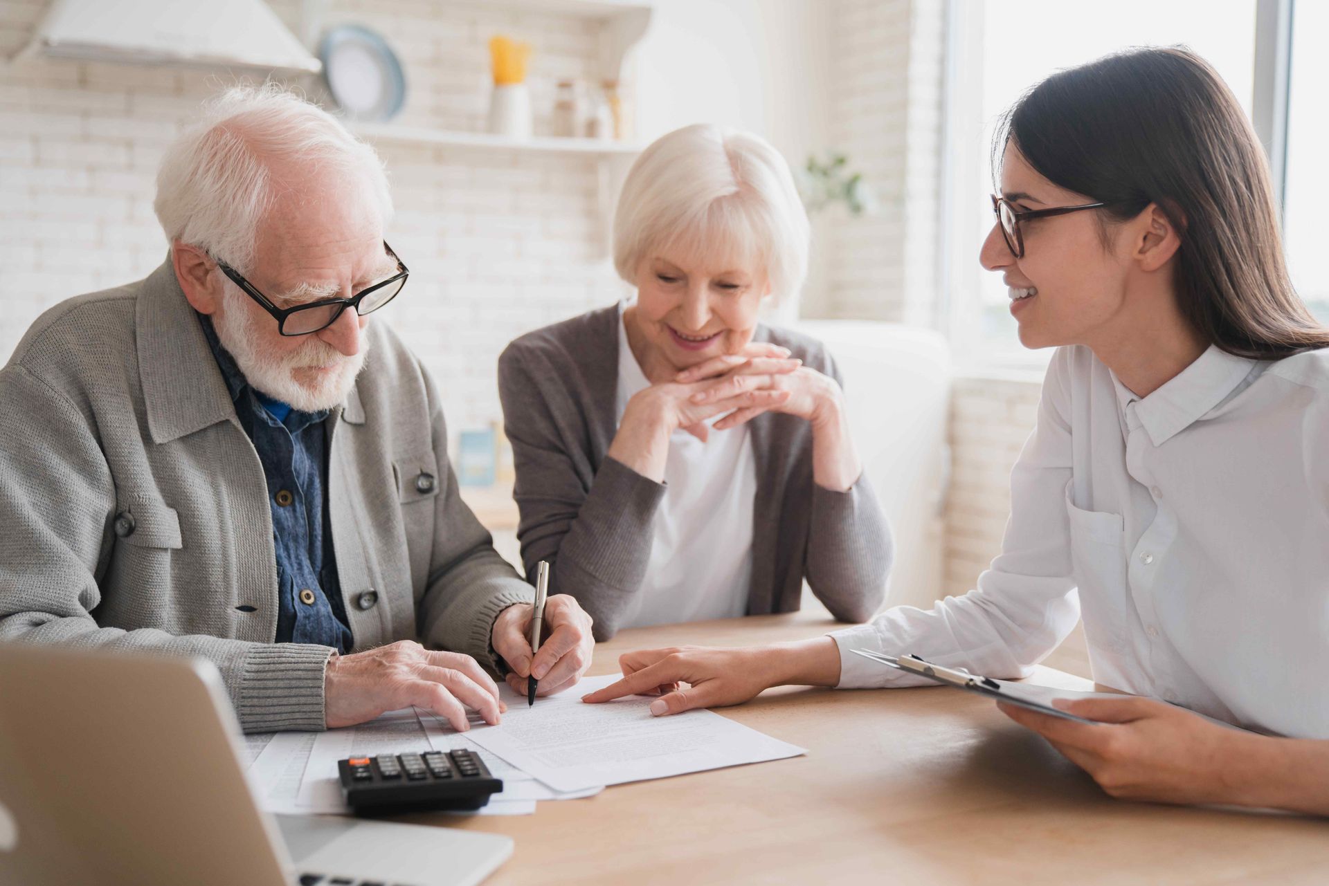 An elderly couple is sitting at a table with a Professional woman.