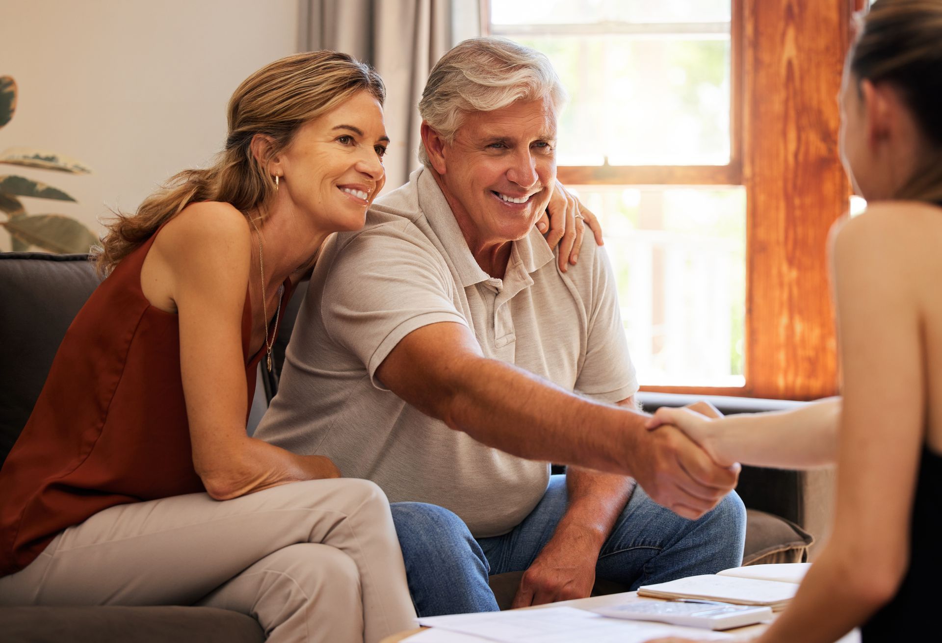 An elderly couple is sitting at a table with a Professional woman.