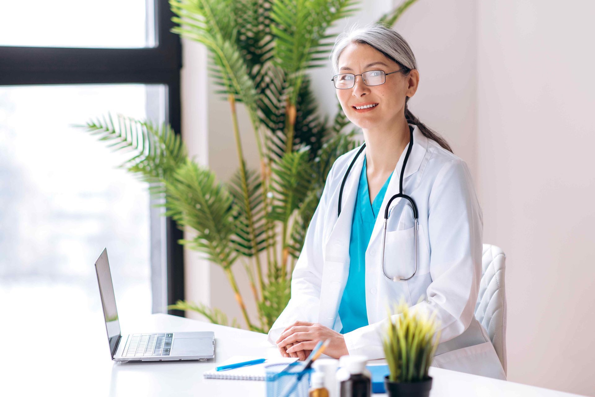 A doctor smiling at the camera who is a Primary Medicare Specialist