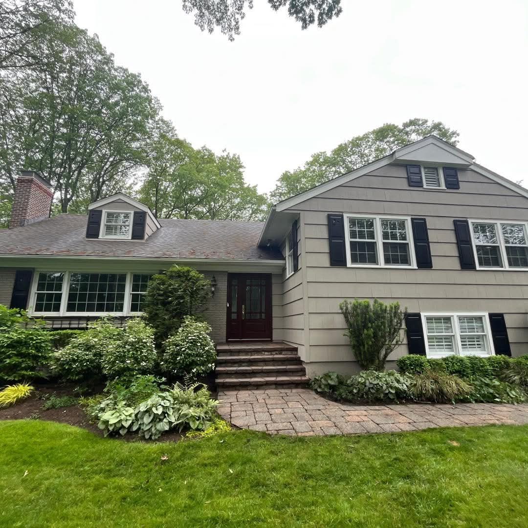 Overhead view of a shingled roof with a gutter. Deck and trees visible in background.