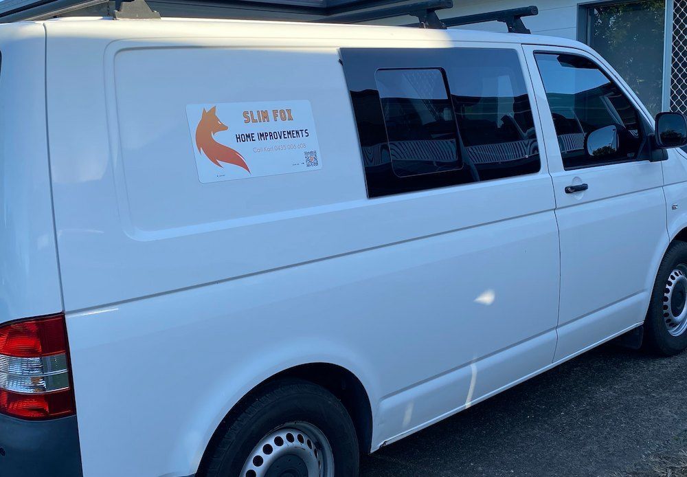 A White Van is Parked in Front of a Building — Slim Fox Home Improvements in Mooroobool, QLD