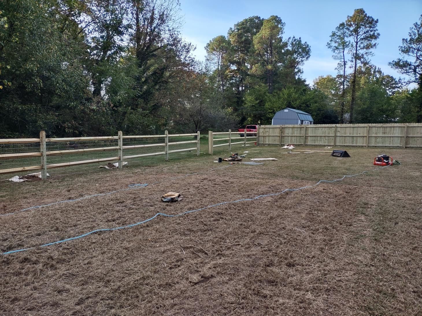A wooden fence with a gate in front of a house.