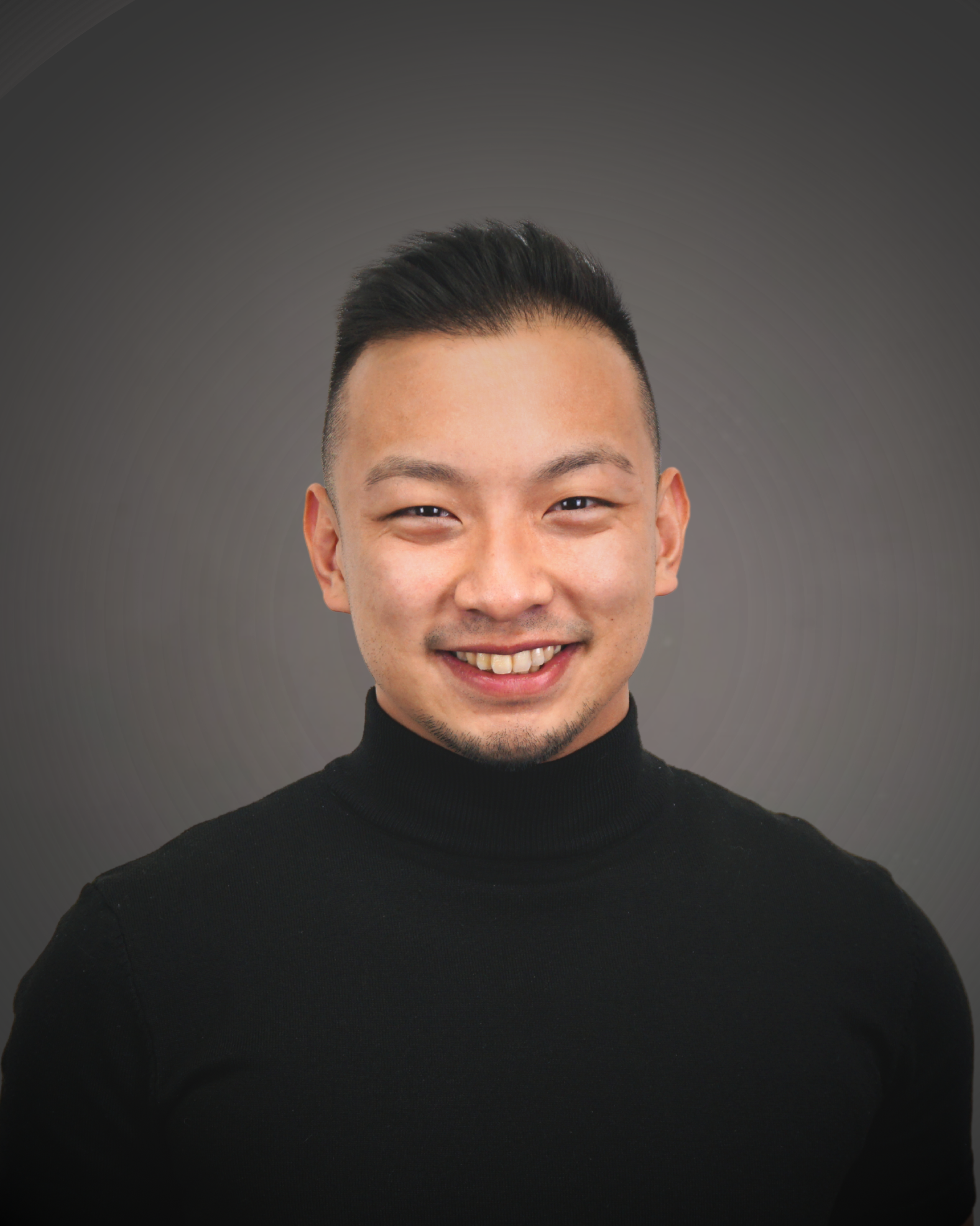 Dr. Gustavo Luna in a suit, smiling, headshot against a gray background.