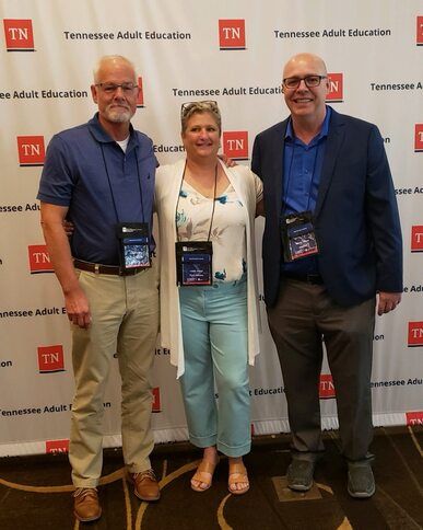 Grant Roddy and Leslie Travis standing with David Tanner at a Tennessee Adult Education event.
