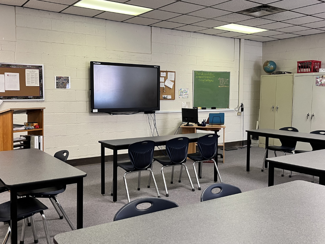 inside a classroom at the Dayton location with classroom tables and chairs, and an instructional tv