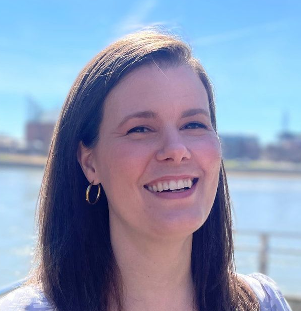 Jessie Evans, IELCE lead instructor, wearing a purple outfit near a scenic waterfront
