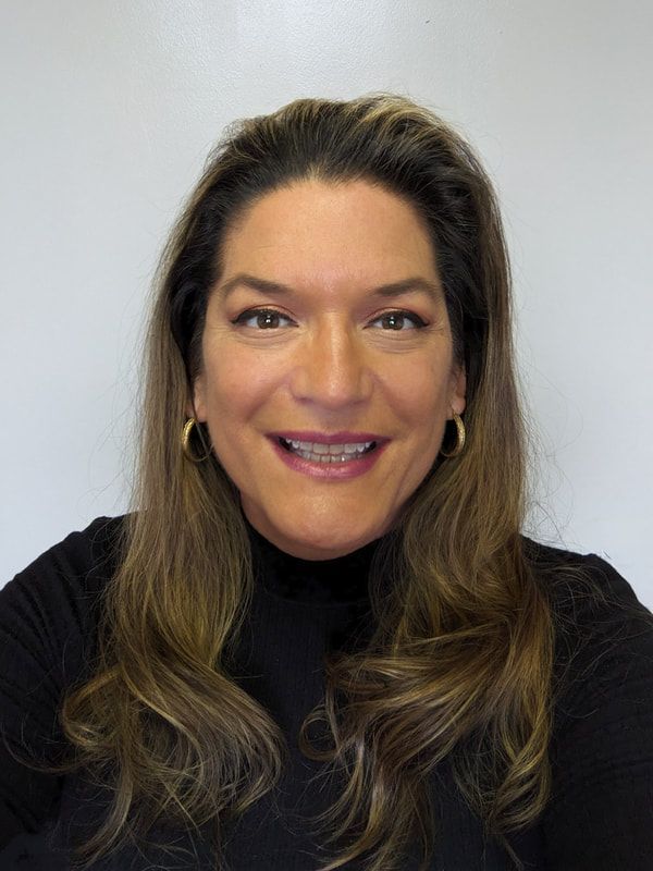 One of the team members, a female smiling in a professional black outfit