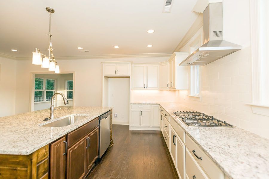 A kitchen with granite counter tops , stainless steel appliances , and a large island.
