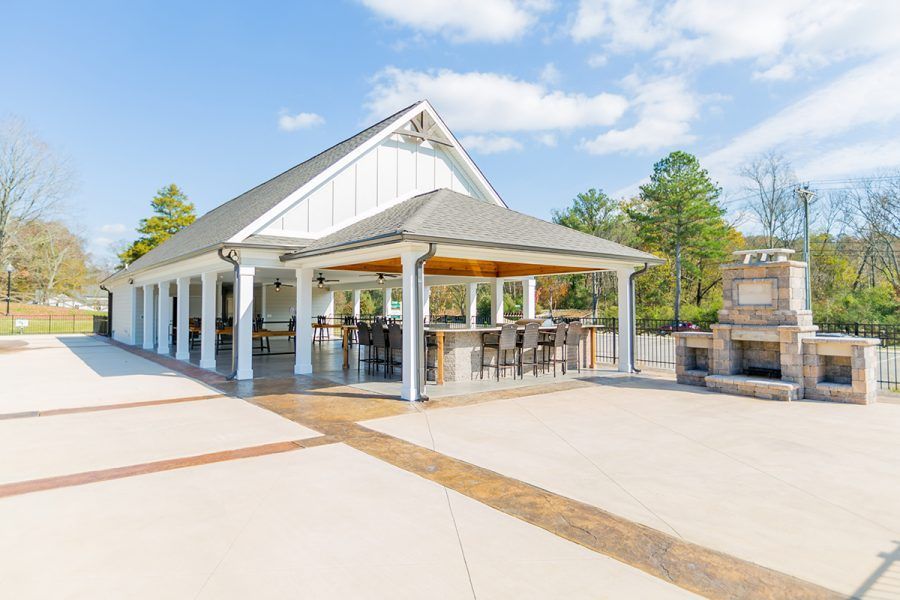 A large white building with a covered patio and a fireplace.