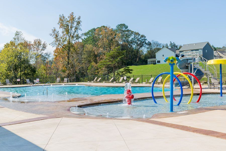 A large swimming pool with a water fountain in the middle of it.