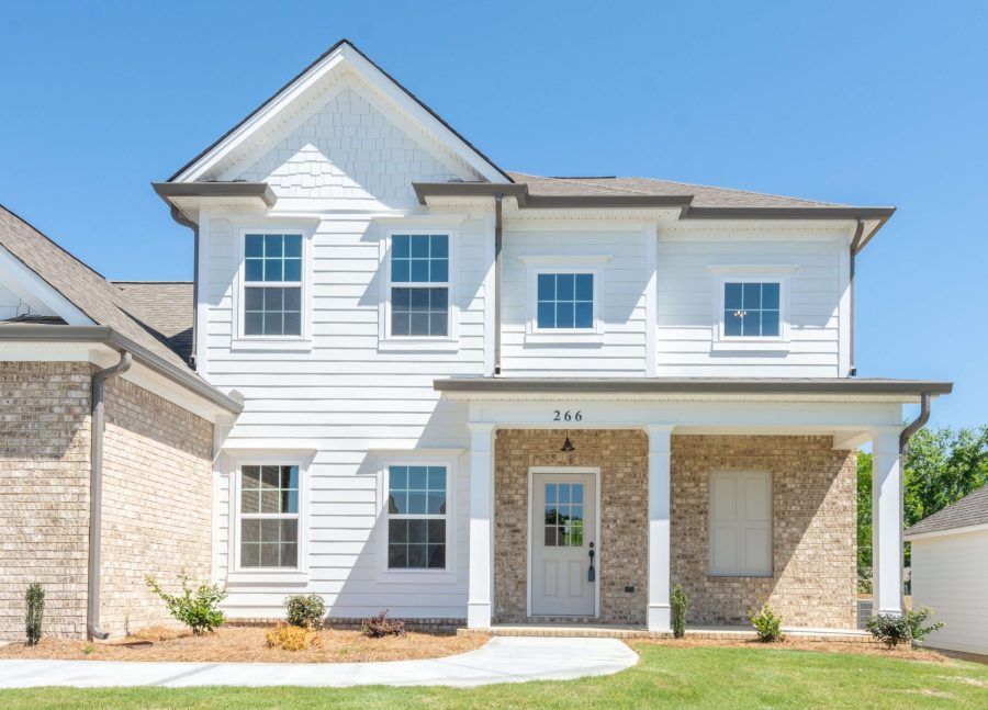 A large white house with a brick exterior and a porch