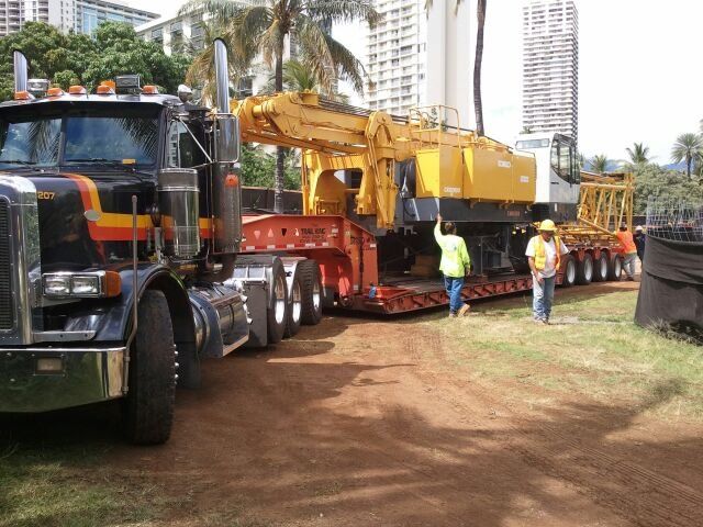 heavy duty crane being transported on a truck