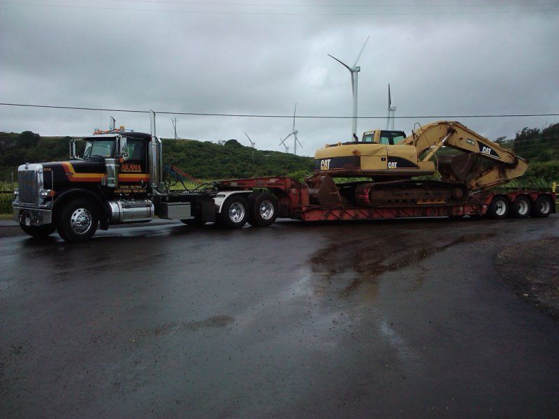 Truck transporting earth moving machine