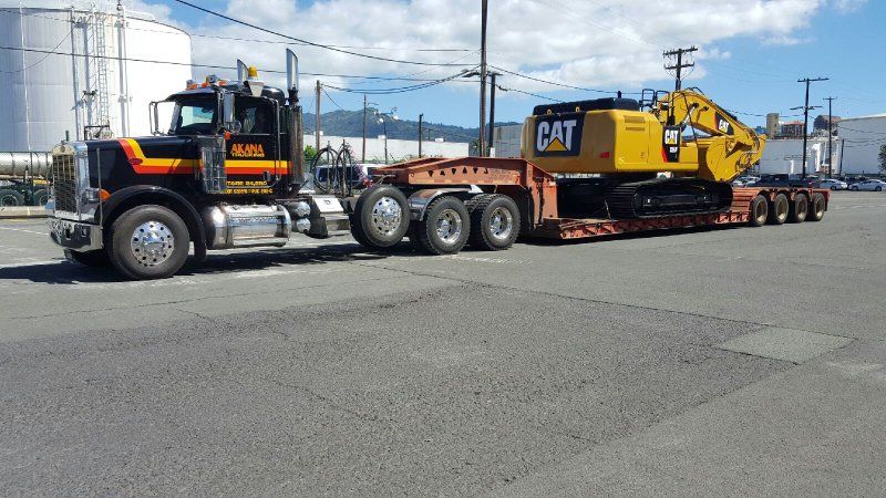 Truck transporting earth moving machine
