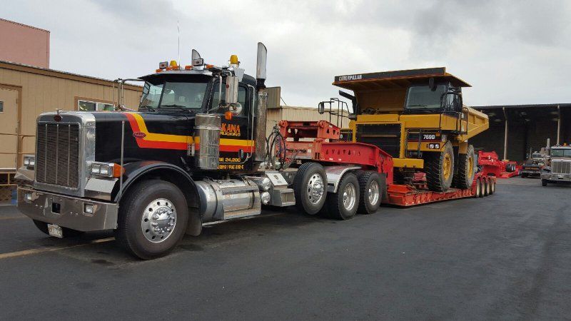 Truck transporting earth moving machine