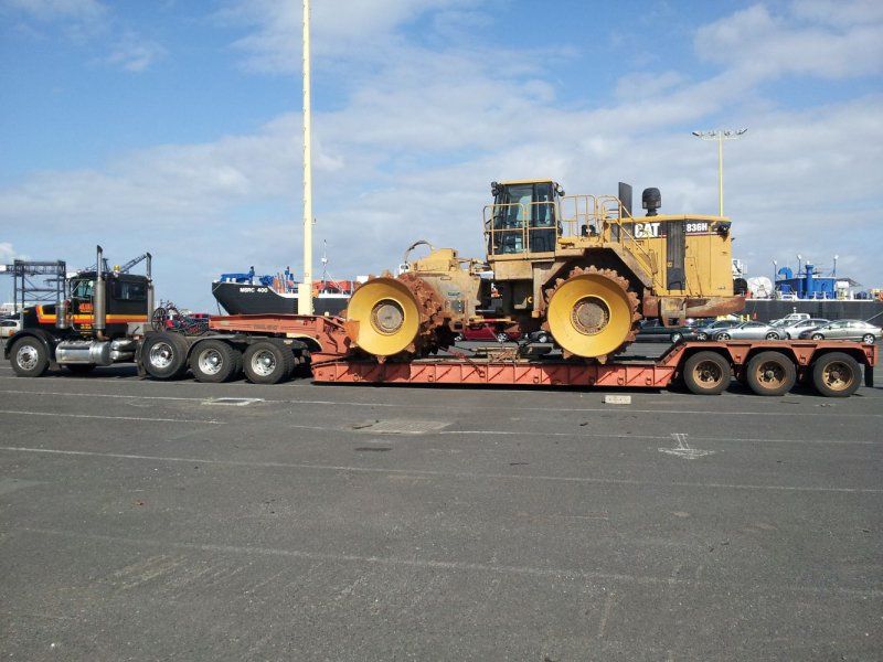 Truck transporting earth moving machine