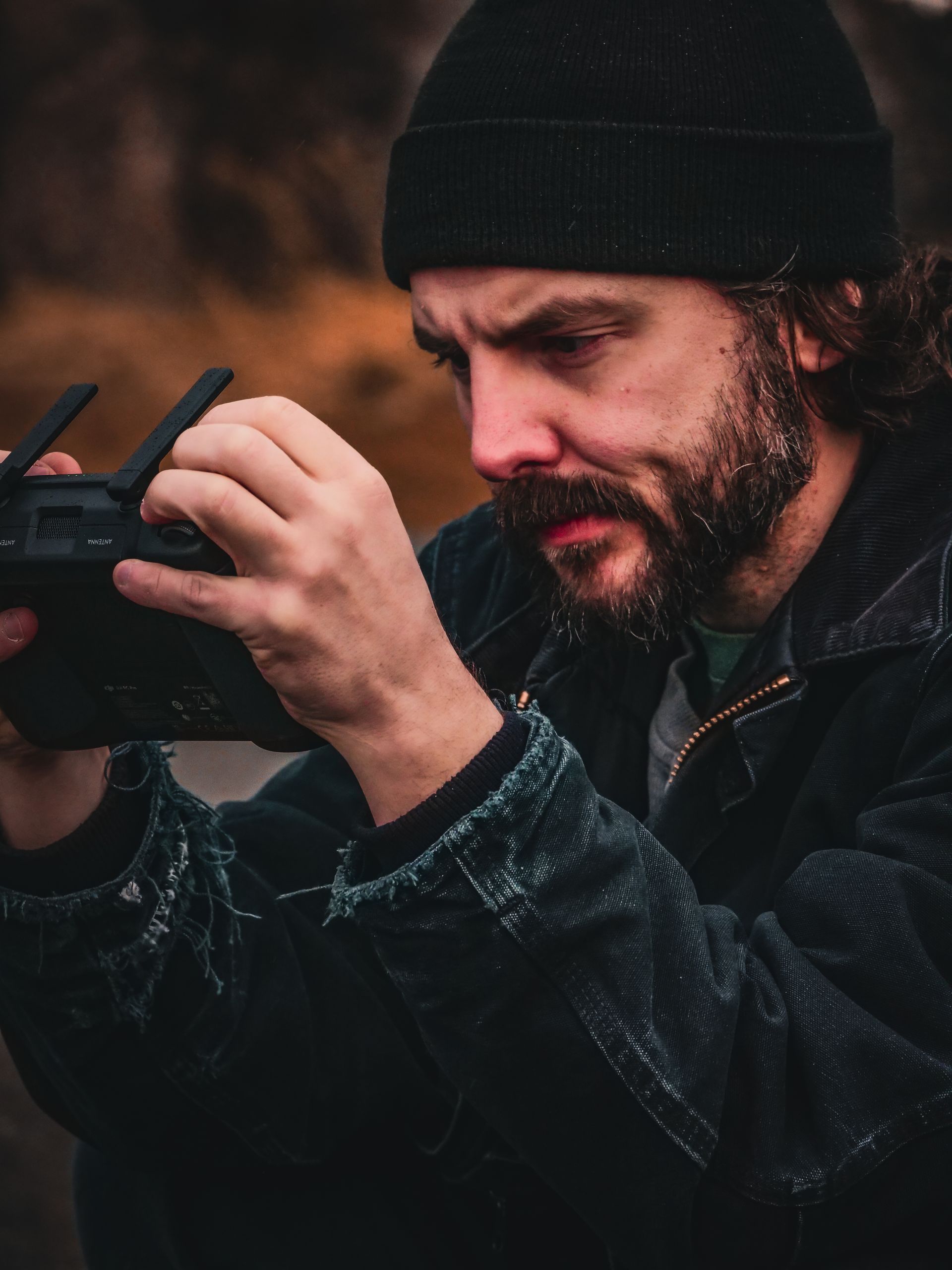 A man in a black hat is holding a remote control