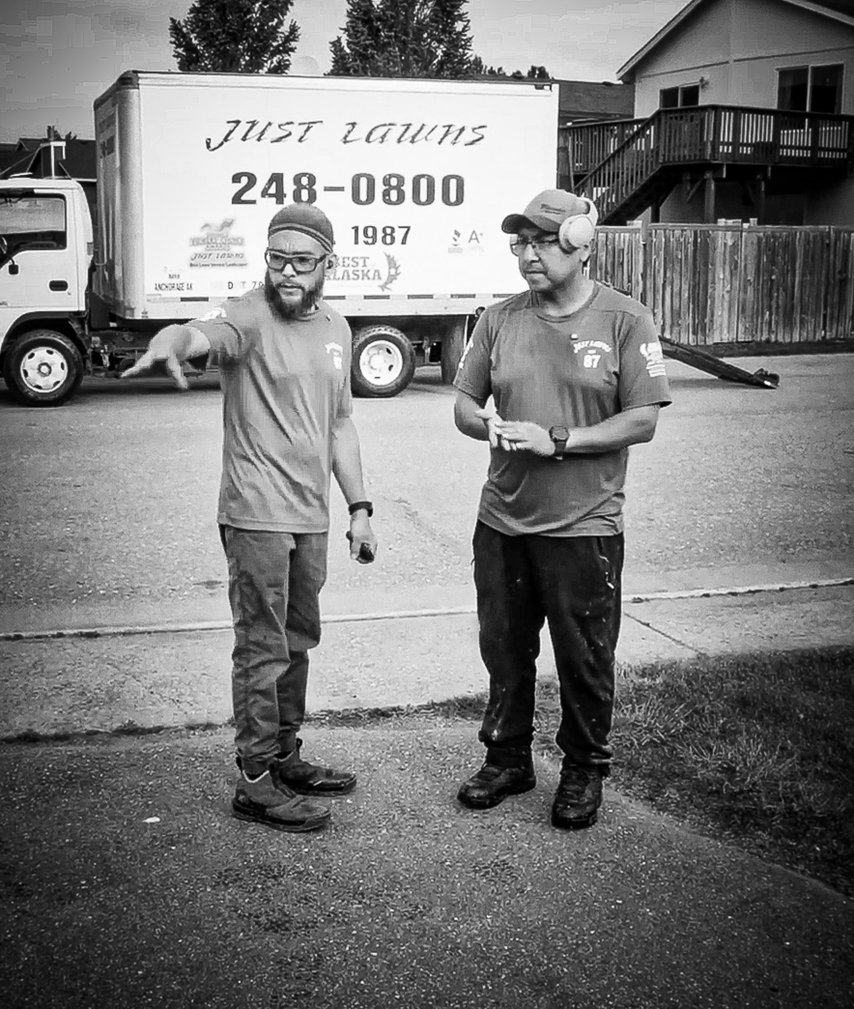 Two men standing in front of a just loading truck