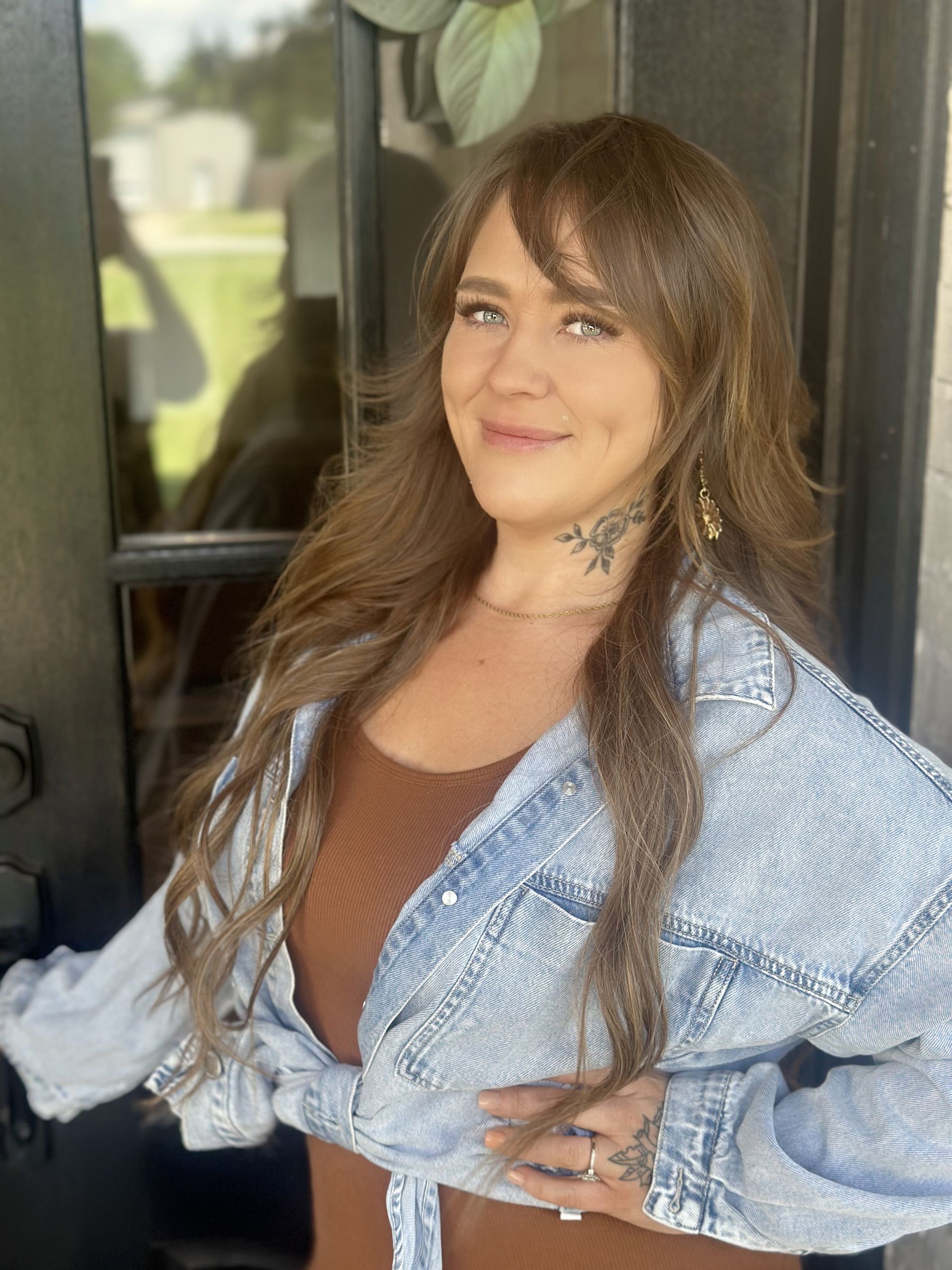 Person working at a wooden desk, with books, plants, and a vase; minimalist, bright interior.
