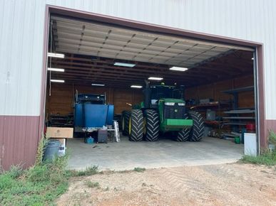 A green john deere tractor is parked in a garage