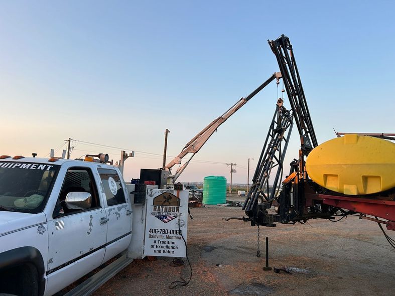 A white truck is parked next to a yellow tank.