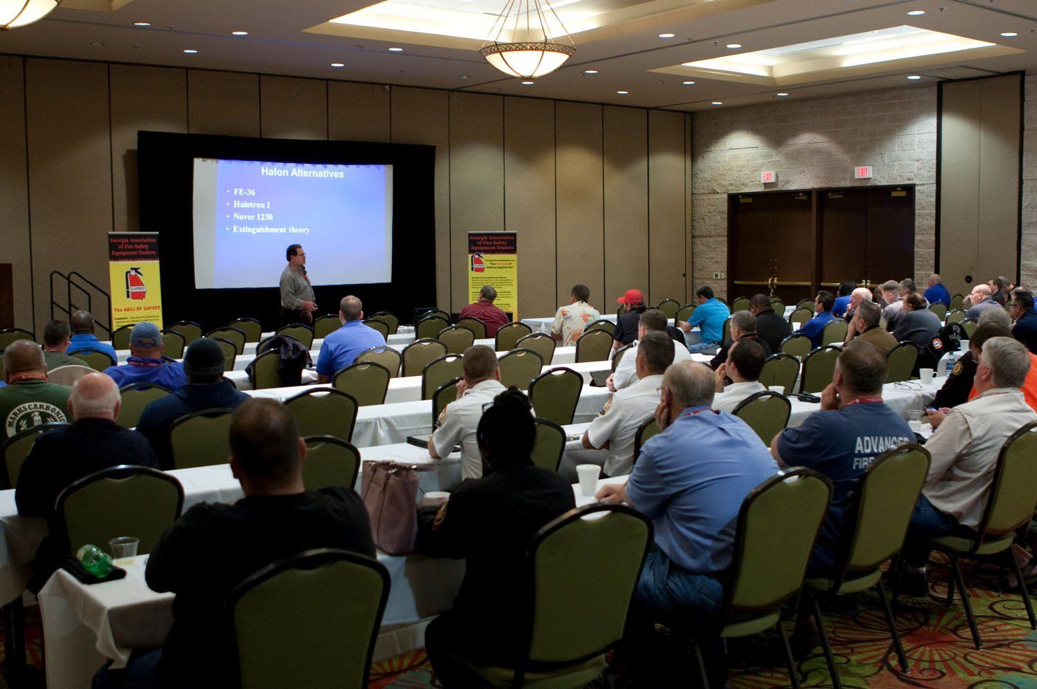 A group of people are sitting in a conference room watching a presentation