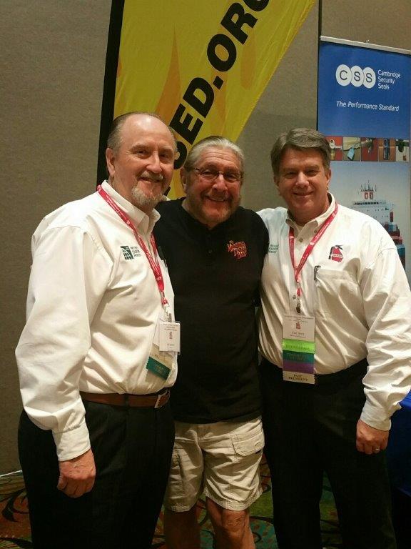 Three men pose for a photo in front of a banner that says ed.org