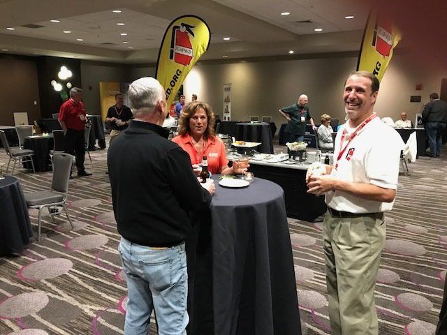 A group of people standing around a table with a fire extinguisher flag in the background