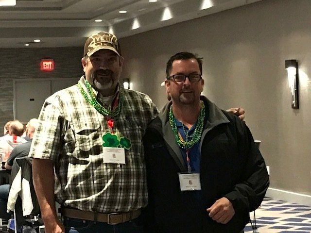 Two men are posing for a picture together in a room.