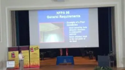 A man is giving a presentation in front of a large screen.