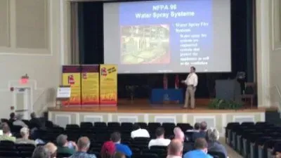A man is giving a presentation to a group of people in an auditorium.