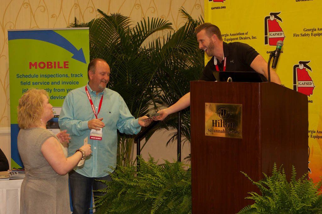 A man giving a woman a thumbs up in front of a sign that says mobile