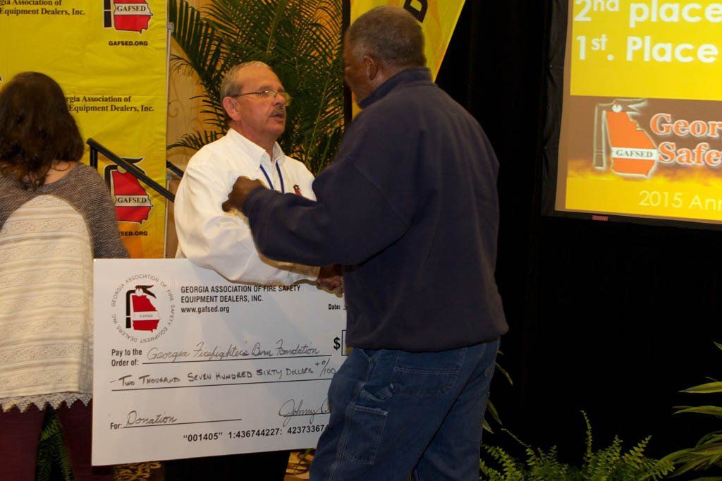 A man holding a check that says 2nd place on it