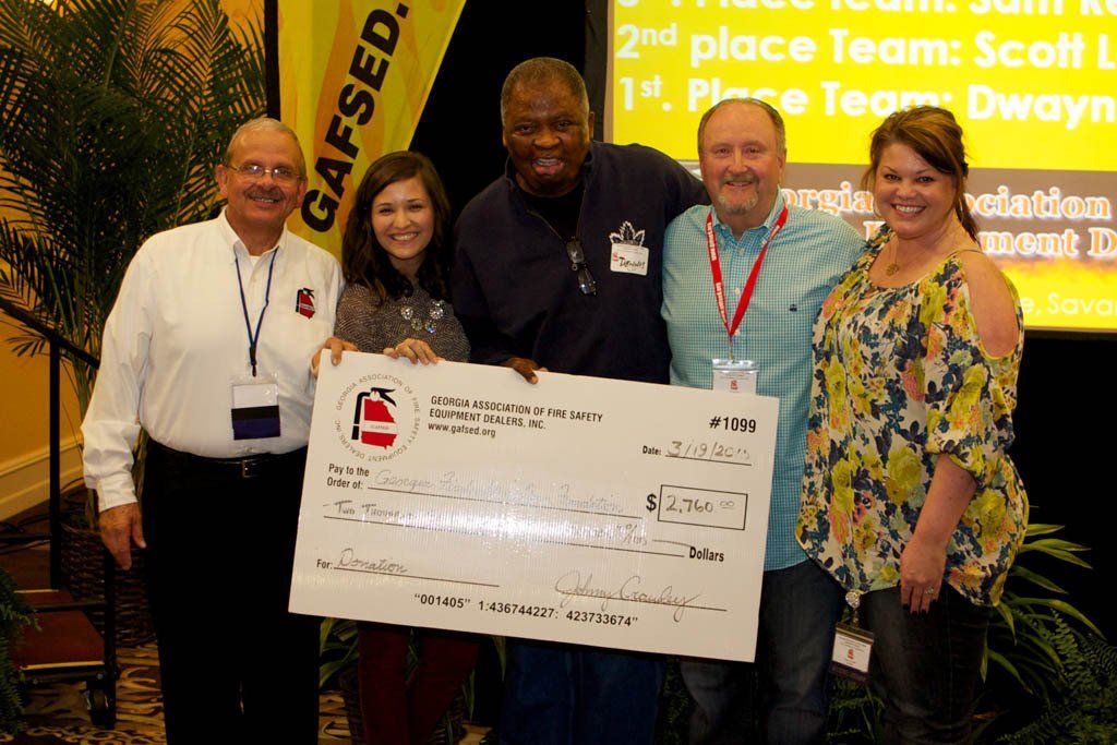 A group of people holding a large check that says gaffed on it