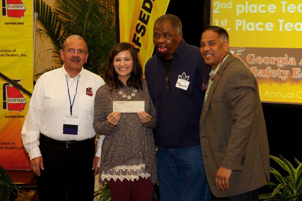 A group of people are posing for a picture with a woman holding a check.