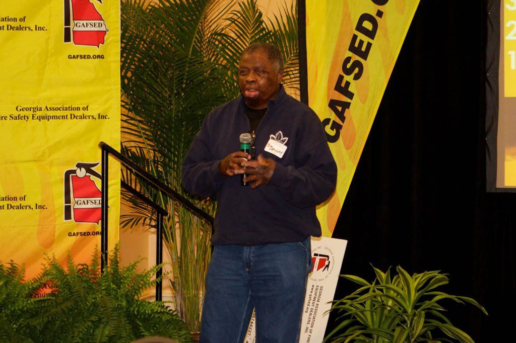 A man stands in front of a sign that says gafsed