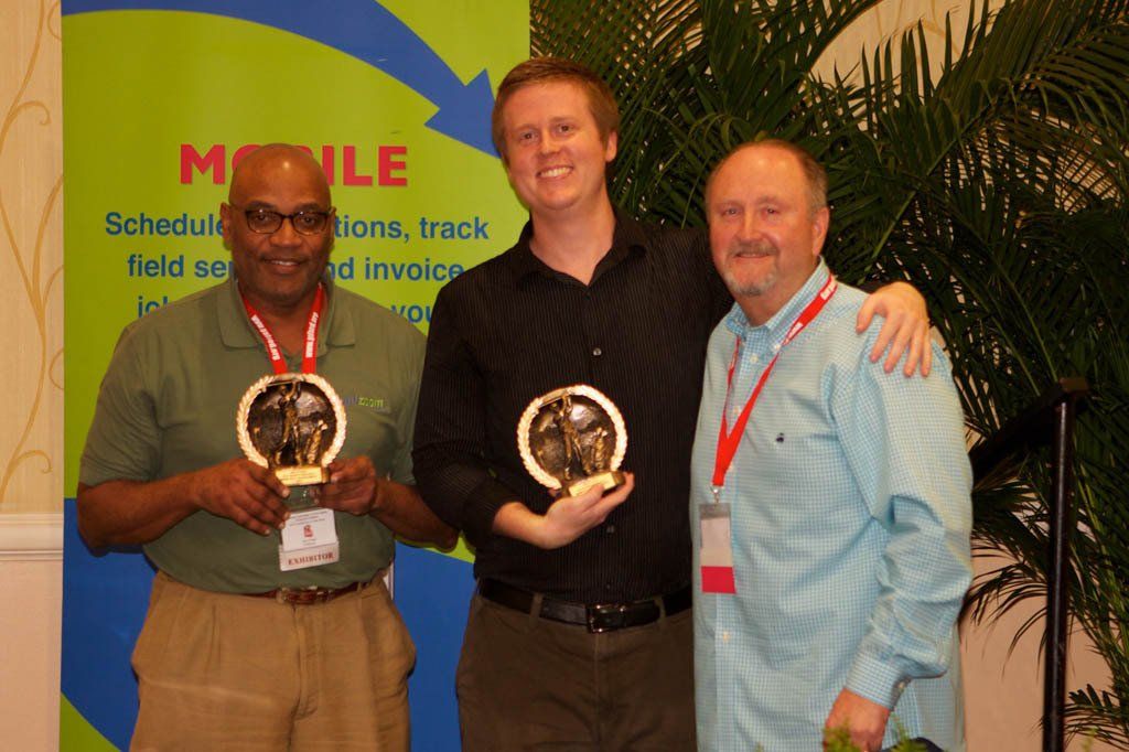 Three men standing in front of a sign that says mobile