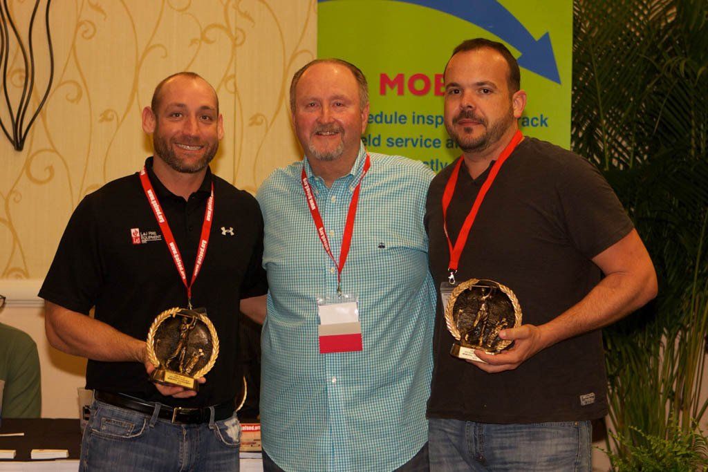 Three men are posing for a picture in front of a sign that says mob
