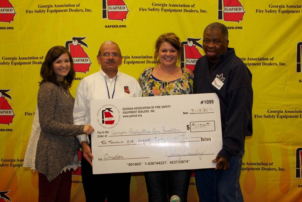 A group of people are holding a large check