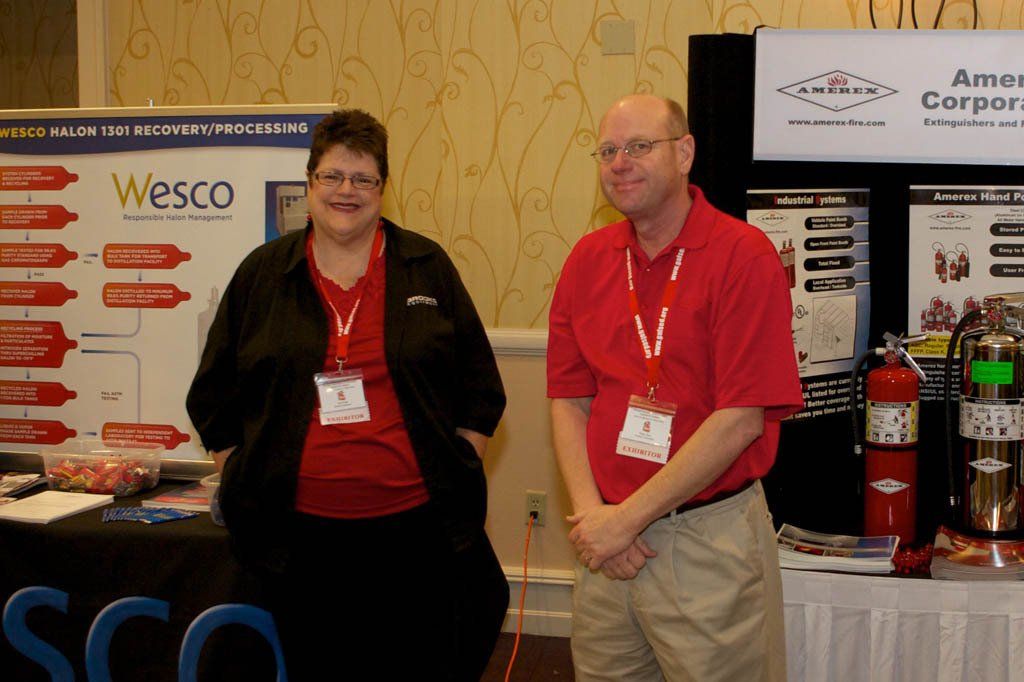 Two people standing in front of a sign that says wesco