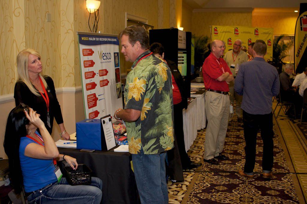 A man in a hawaiian shirt is talking to a woman at a table